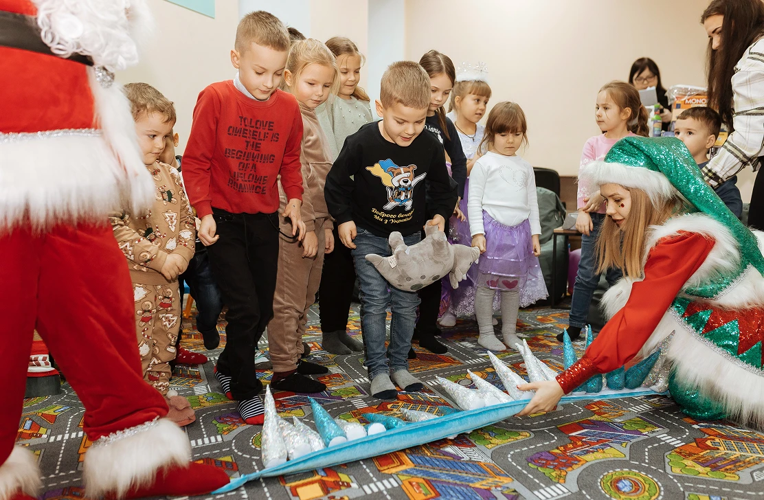 Children playing a game with costumed hosts at a New Year party