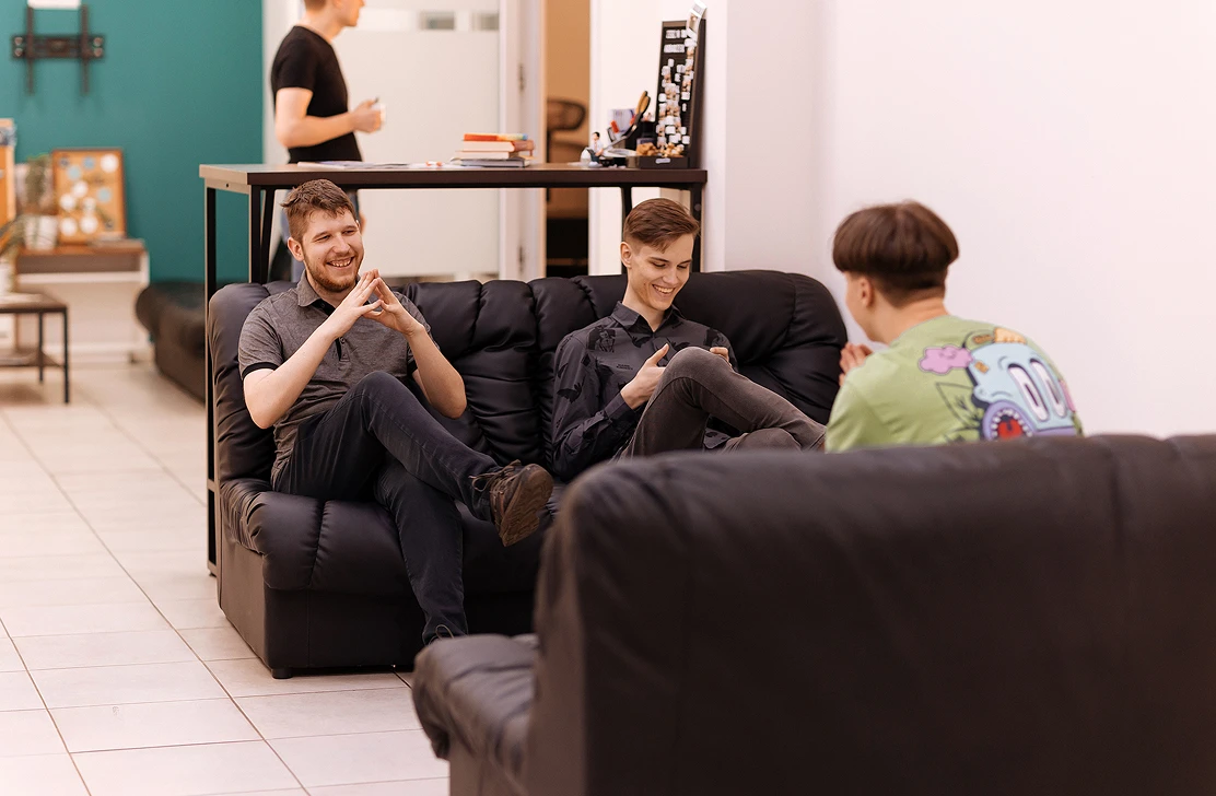 Colleagues talking on the sofas in the Go Wombat office